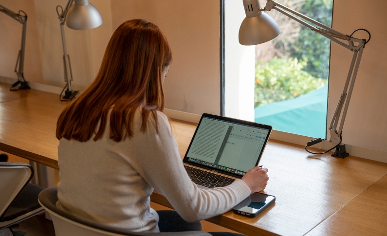 Student studying on her computer in the library