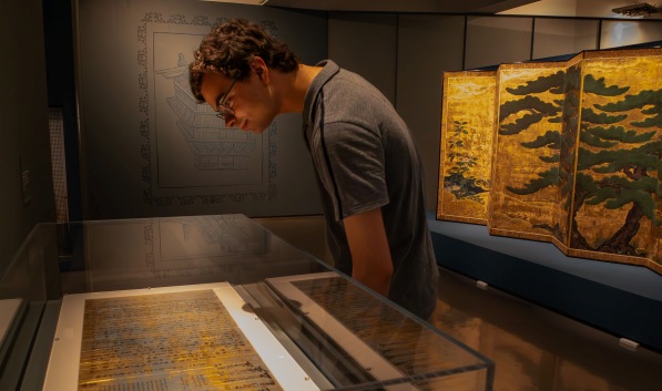 Art History student looking at manuscripts behind glass