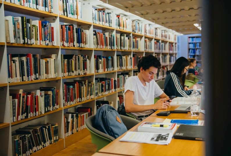 Student reading book in library