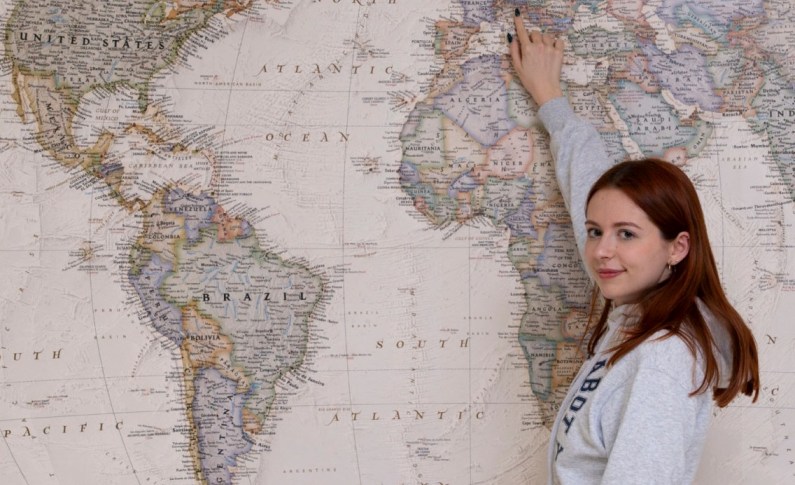 Student pointing at Italy on a map