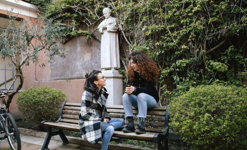 Students talking to one another on a bench